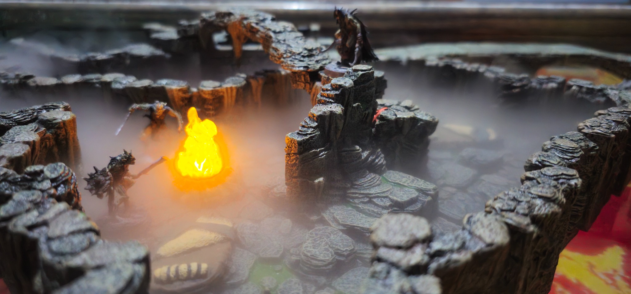 Fog-covered fantasy dungeon terrain with illuminated miniatures